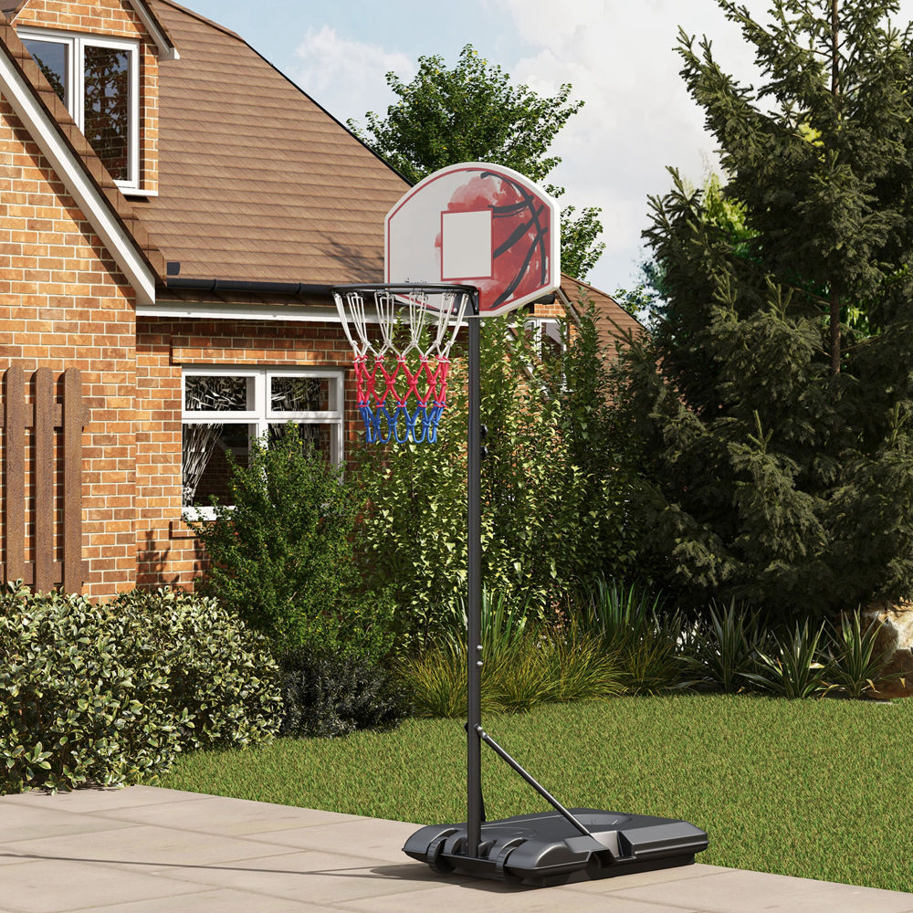 Basketballkorb aufgestellt im Garten eines Ziegelhauses, bereit zum Spielen.