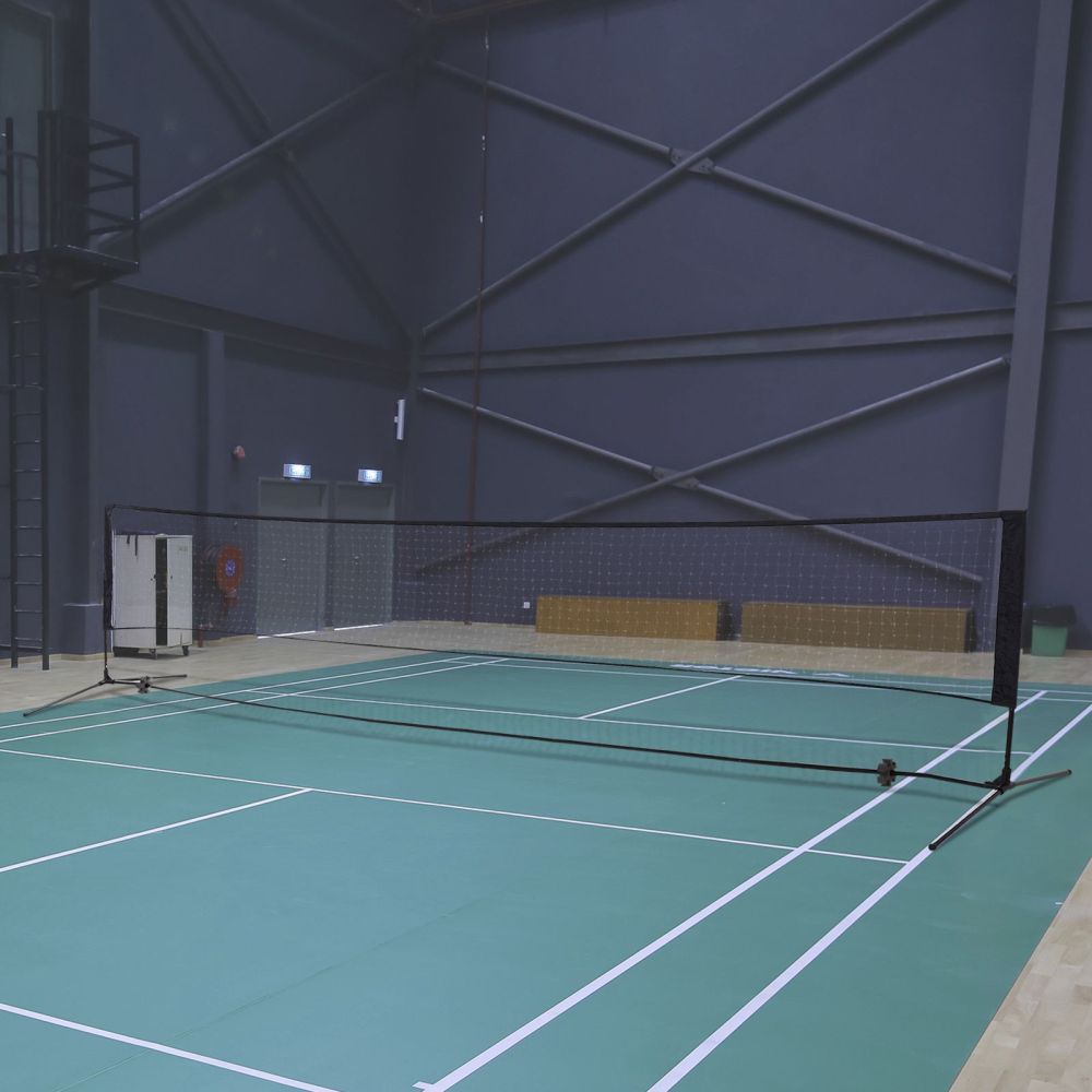 Das Badmintonnetz aufgebaut in einer Sporthalle auf einem grünen Spielfeld.