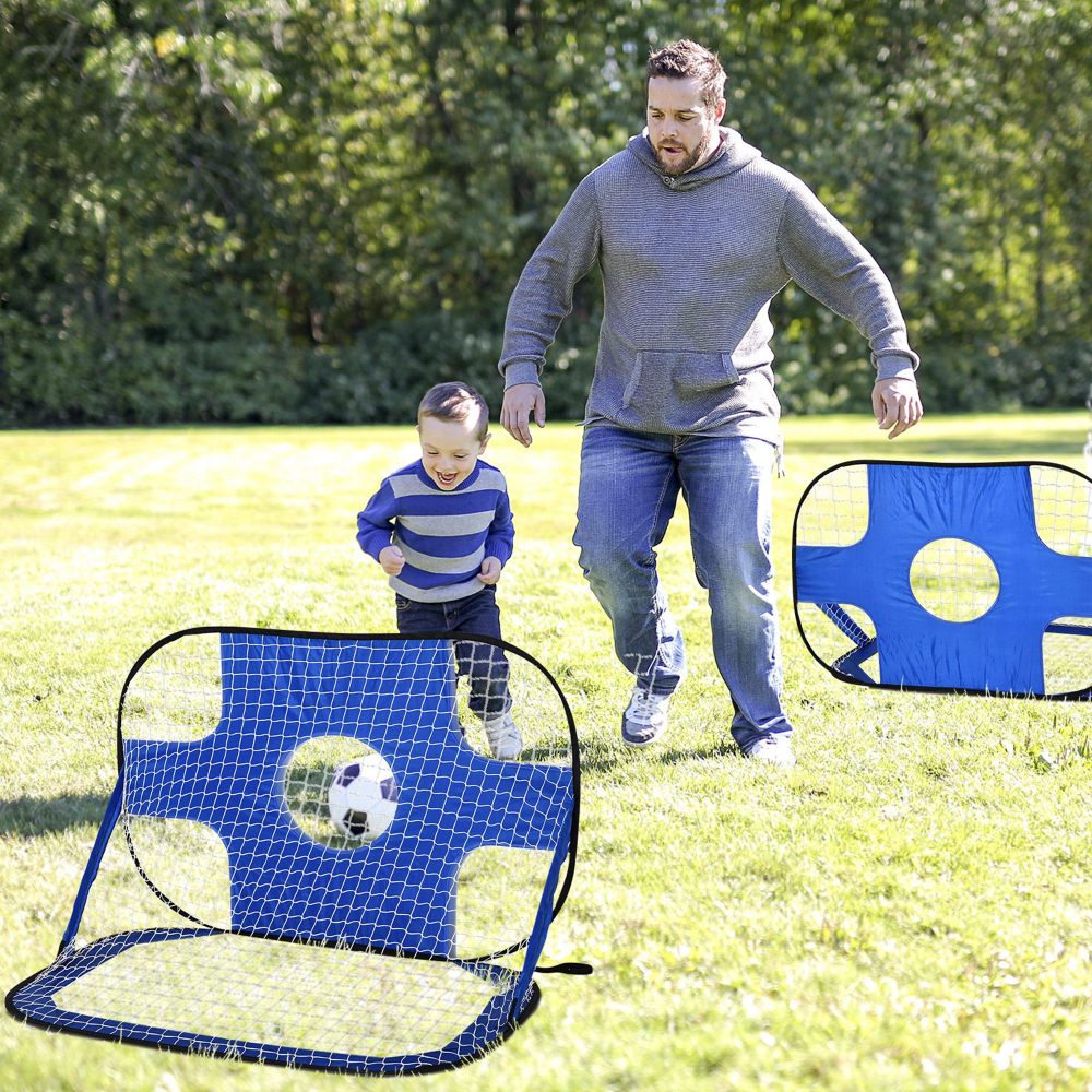 Ein Vater und sein kleiner Sohn spielen fröhlich Fußball im Garten mit den blauen Minitoren.
