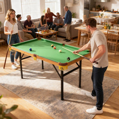 Familie und Freunde versammelt um den grünen Mini Billardtisch für ein gemeinsames Spiel im Wohnbereich