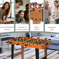 Gruppe von Freunden hat Spaß beim gemeinsamen Tischfußball-Turnier im Wohnzimmer