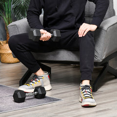 Hantel-Set Training: Mann nutzt zwei 5kg Hanteln auf dem Sessel