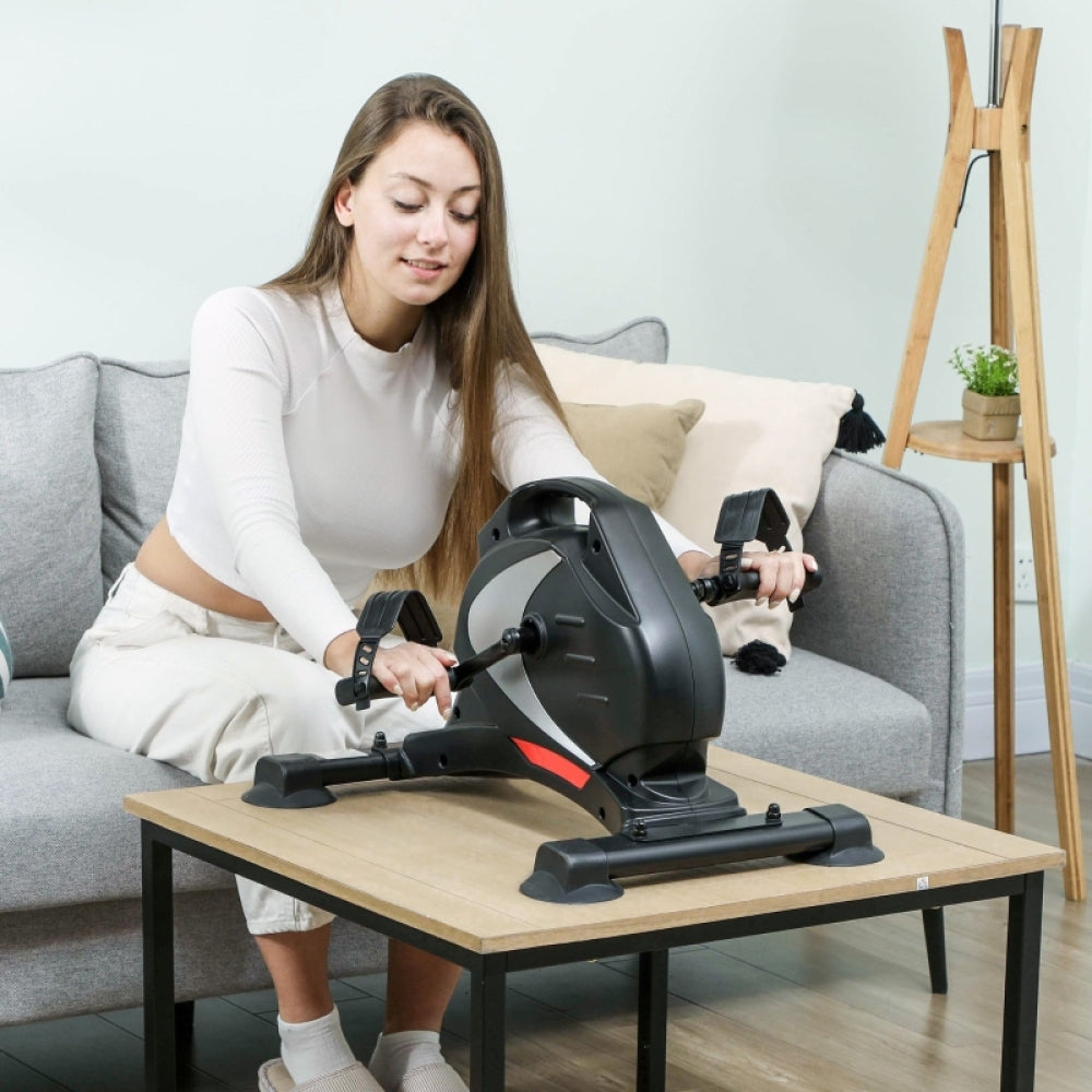 Armtraining zu Hause: Frau nutzt den Pedaltrainer auf dem Couchtisch