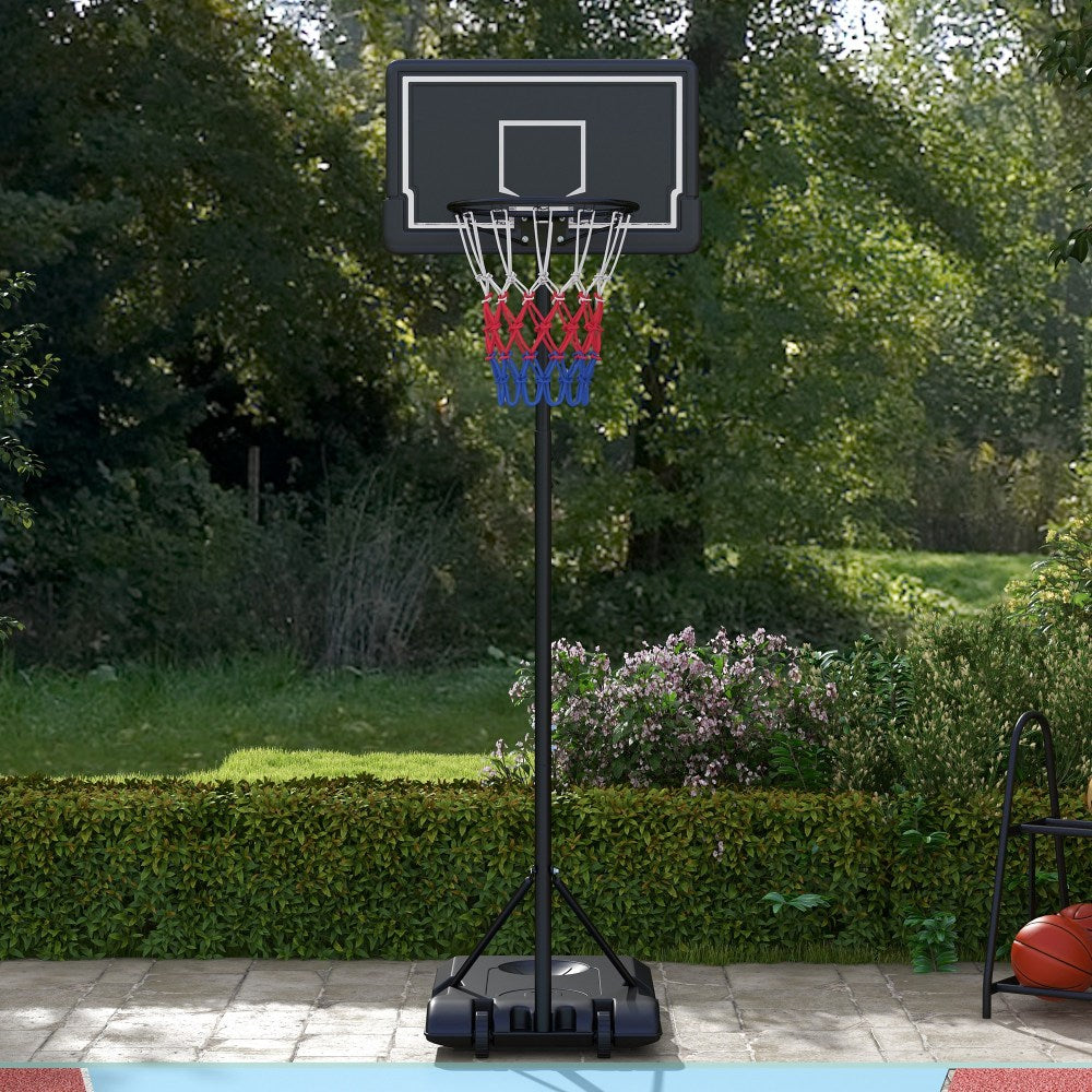 Der Basketballkorb steht stabil in einem grünen Garten vor einer Hecke.