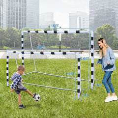 Ein Junge schießt einen Fußball auf das Tor während eines sonnigen Tages im Park.