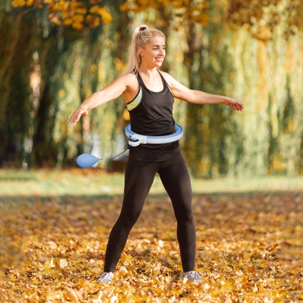 Eine Frau nutzt den Fitnessreifen zu Hause, um ihre Taille zu trainieren und Kalorien zu verbrennen.