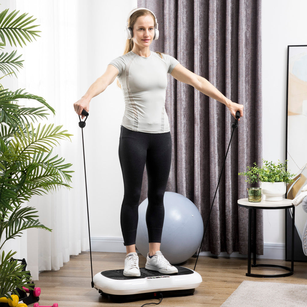 Frau beim Ganzkörpertraining mit Widerstandsbändern auf der Vibrationsplatte