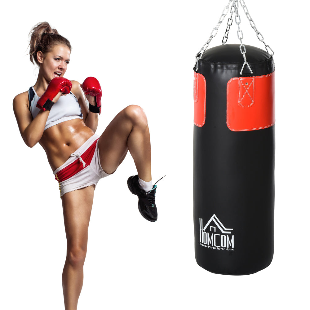 Frau beim Kickbox-Training am hängenden Sandsack, führt einen High-Kick aus.