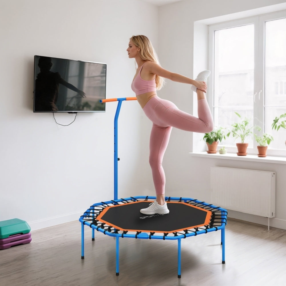 Frau dehnt sich am Griff des blauen Trampolins nach dem Sport.