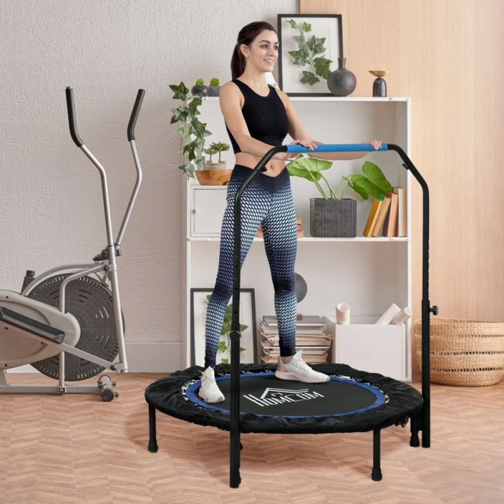 Frau in Sportkleidung steht bereit auf dem Trampolin im Wohnzimmer, Hände am blauen Griff.