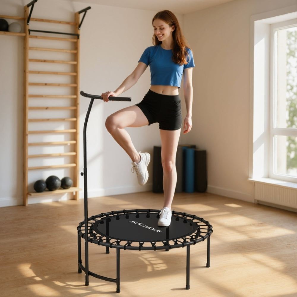 Frau macht Step-Übungen auf dem schwarzen Trampolin, hält sich am T-Griff fest.