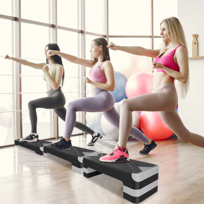 Frauengruppe beim gemeinsamen Step-Aerobic-Kurs im Fitnessstudio.