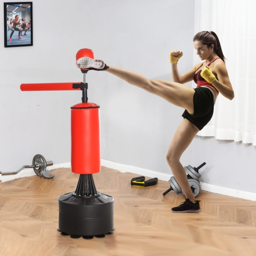 Kickbox-Training zu Hause: Frau beim High-Kick gegen den roten Standboxsack.