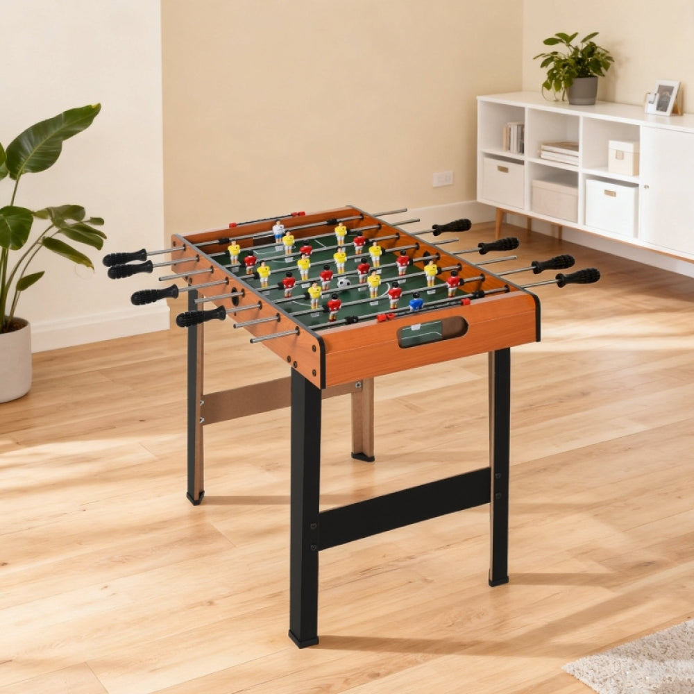 Kind spielt am Tischkicker mit langen Beinen im hellen Kinderzimmer