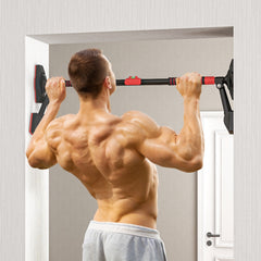 Muskulöser Athlet führt Klimmzüge an der installierten Stange im Türrahmen aus.