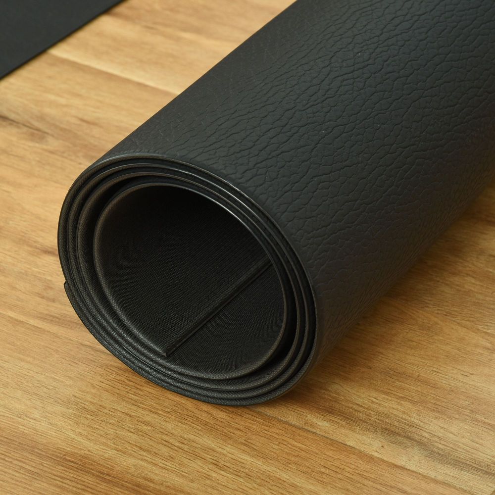 Sunjetfit Fitnessunterlage – Aufgerollte schwarze Schutzmatte auf Holzboden, flexibel und langlebig
