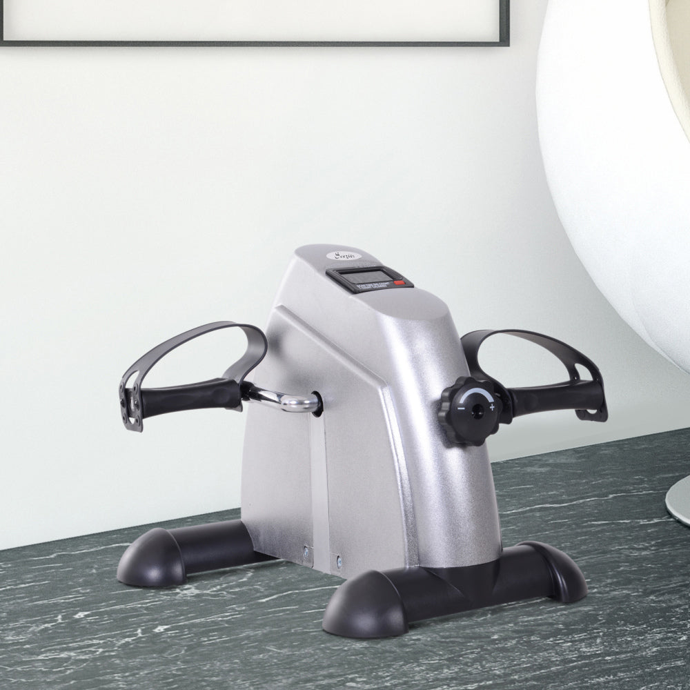 H105 Mini-Heimtrainer Grau – Kompakter Arm- und Beintrainer auf dem Tisch im Wohnzimmer